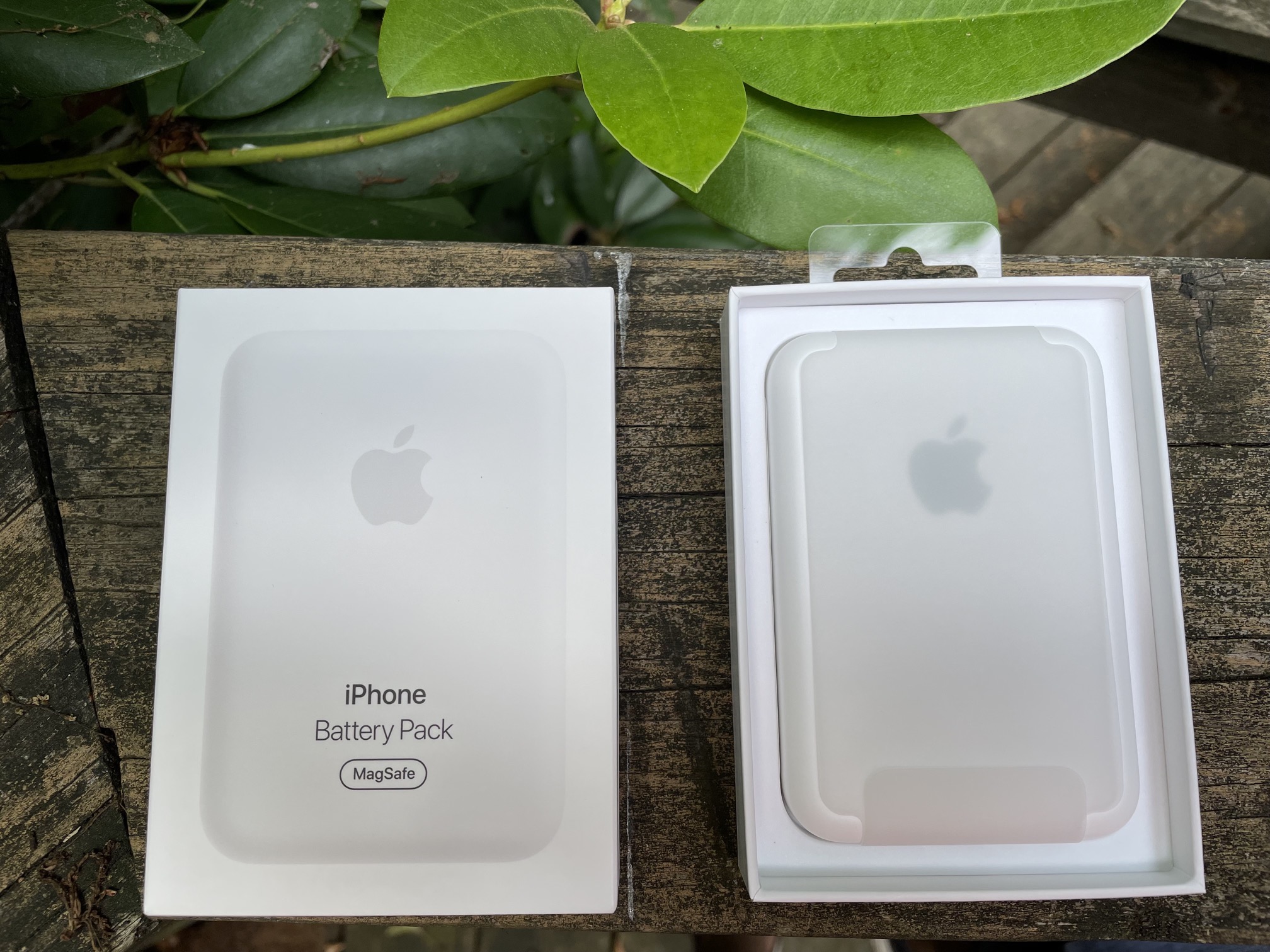 The MagSafe Battery Pack resting in its packaging on a wooden railing